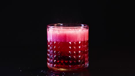 effervescent red drink in a patterned glass