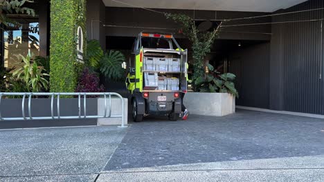 postman delivering mails and parcels in the latest battery-operated electric vehicle, australia post combatting climate change, reducing environmental impact, brisbane city, queensland