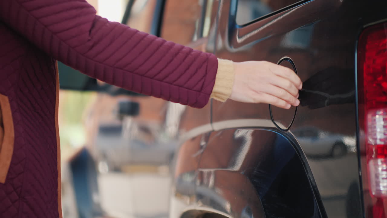 여자는 검은 차에 가스를 펌프