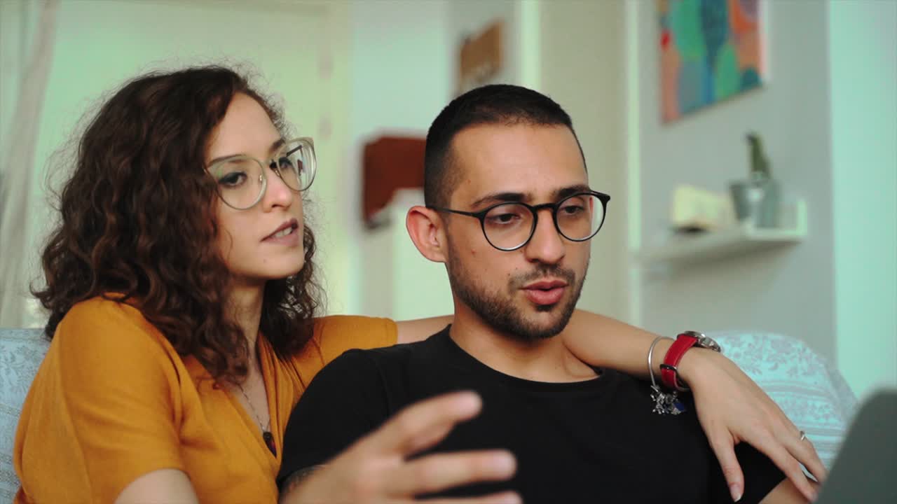 pareja feliz teniendo una conversación de video en una computadora portátil en casa