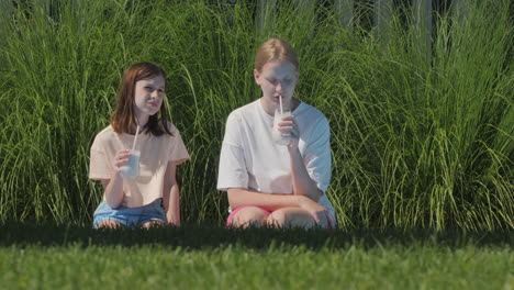 two girls enjoying drinks outdoors