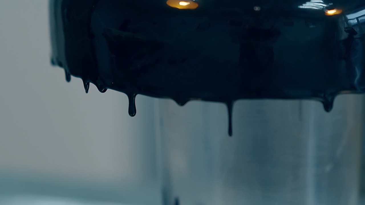 las gotas de chocolate oscuro caen sobre la superficie de cocción