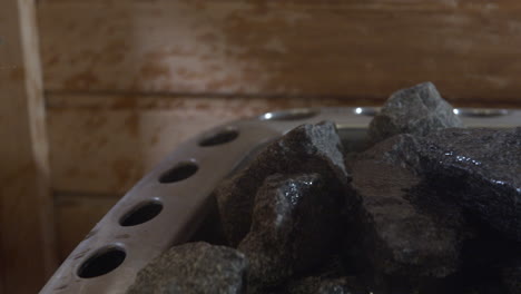 pouring water on the rocks from a sauna heater