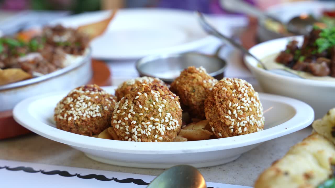 Appetizing close-up of golden falafel with sesame seeds served on a white plate, perfect for promoting Mediterranean, vegetarian, or healthy cuisine