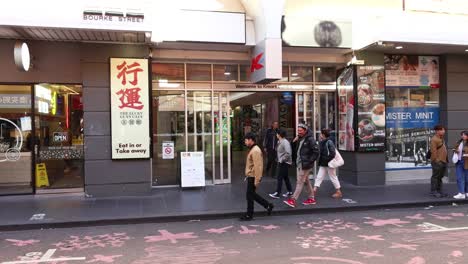 pedestrians walking by a shop in melbourne