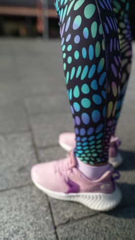 mujer estirándose en leggings y zapatillas de deporte coloridas