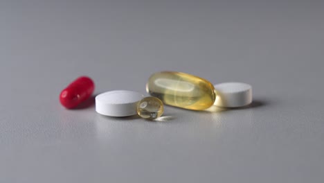 Static-zoom-in-shot-of-different-color-medicine-pills-and-capsules-on-table