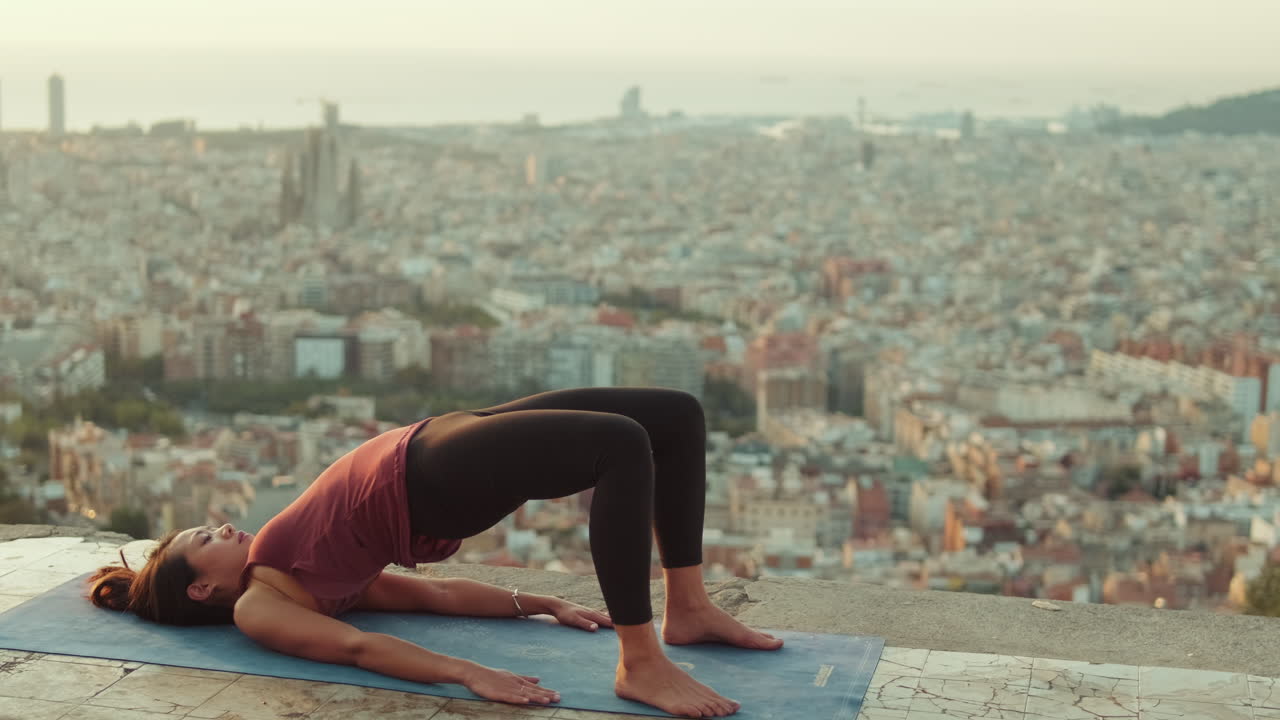 Donna che esegue la posizione del ponte di yoga con vista sulla città