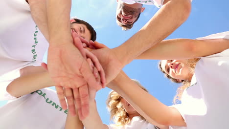 team of volunteers putting hands together