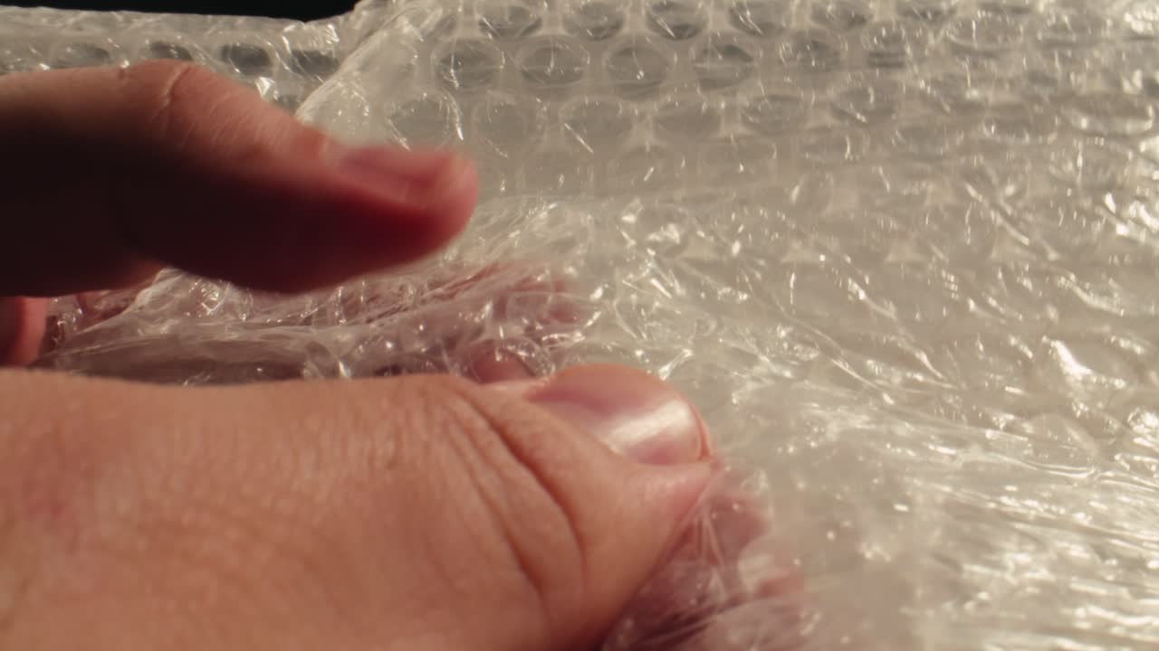 Close-Up of Hand Popping Bubble Wrap for Stress Relief