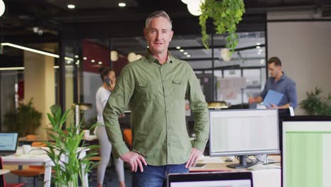 portrait of happy caucasian businessman looking at camera at office