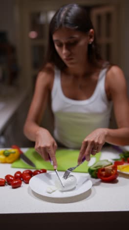 woman preparing a fresh mozzarella salad in a kitchen