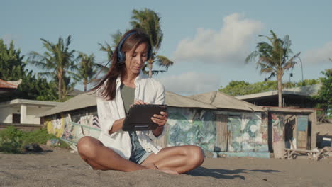 woman with laptop sitting on sand