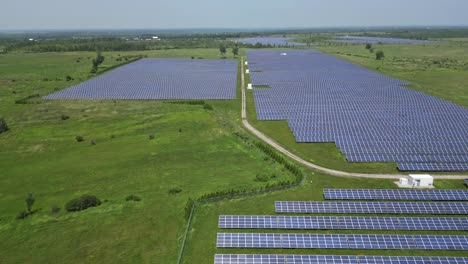 Solar-Electricity-Panel-Installation-In-Green-Fields---aerial-drone-shot