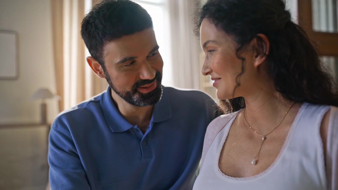 Loving husband caressing pregnant belly wife. Happy smiling couple bonding home.