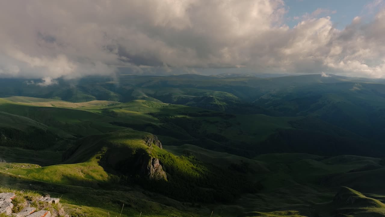 nubes bajas sobre una meseta montañosa en los rayos del atardecer. atardecer en la meseta de bermamyt norte del cáucaso, karachay-cherkessia, rusia.