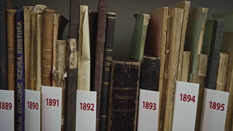 Una-Toma-De-Libros-Antiguos-Colocados-En-La-Estantería,-La-Cámara-Viaja-De-Derecha-A-Izquierda
