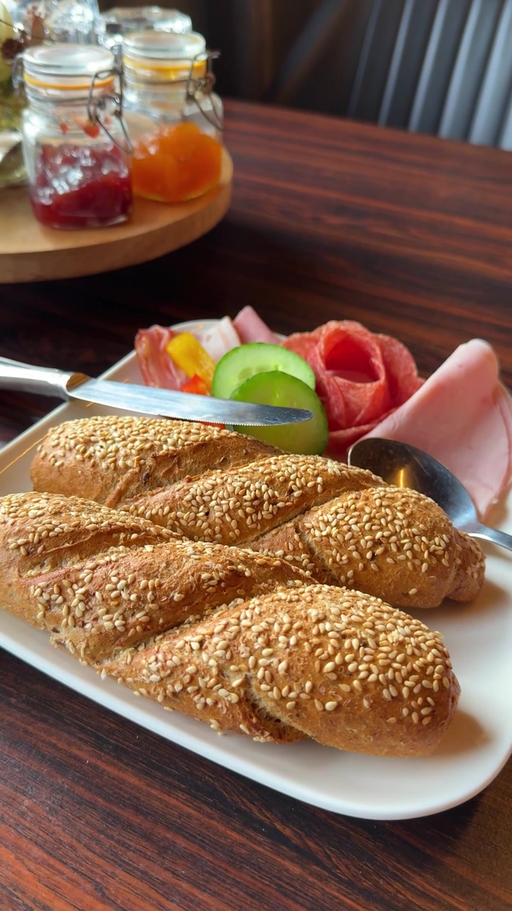 Freshly served breakfast with pastries and coffee on a café table. Perfect for hospitality, brunch, restaurants, travel, lifestyle, and food advertising. Vertical footage of a food bread and veggies