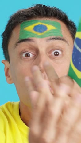 man with brazilian national flag upset with a football referee