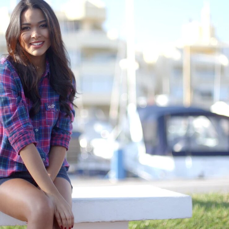 Young Woman Sitting On Bench In Harbor