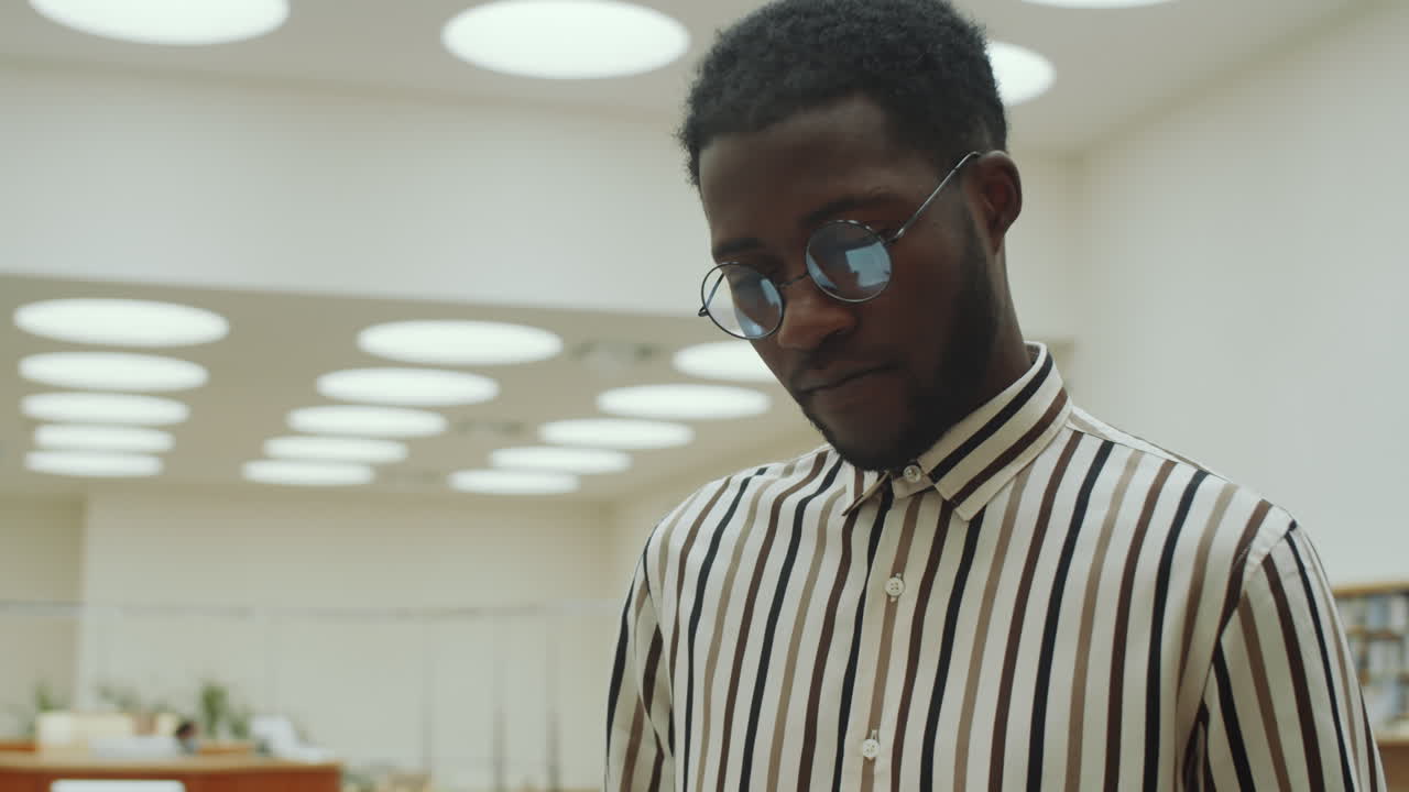 Uomo afroamericano che legge in biblioteca
