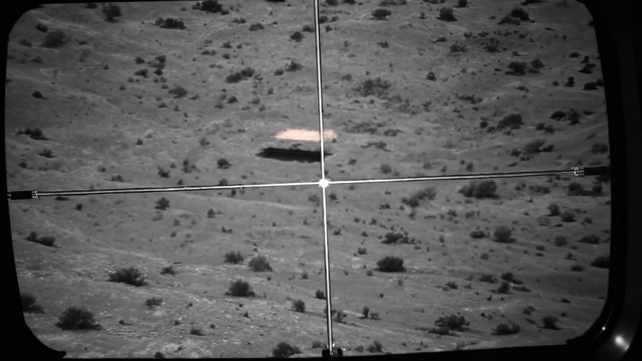 Thermal imaging camera displaying a desert landscape with a military vehicle in the crosshairs, highlighting the precision and targeting capabilities of modern warfare technology
