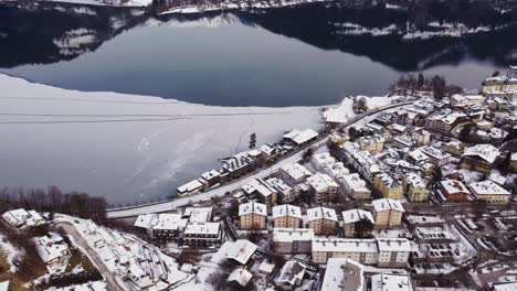 frozen lake and townscape of zell am see, austrian winter town, aerial sideways