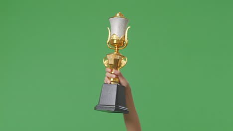 mujer sosteniendo un trofeo de oro campeón. fondo de pantalla verde