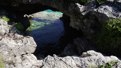 Ground-View-of-Grotto-cliff,-rocks-and-clear,-turquoise-waters