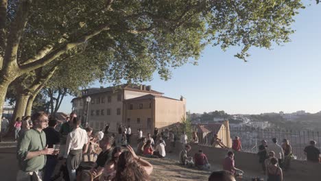 people enjoying the sunset at parque das virtudes in porto, with views of the douro river