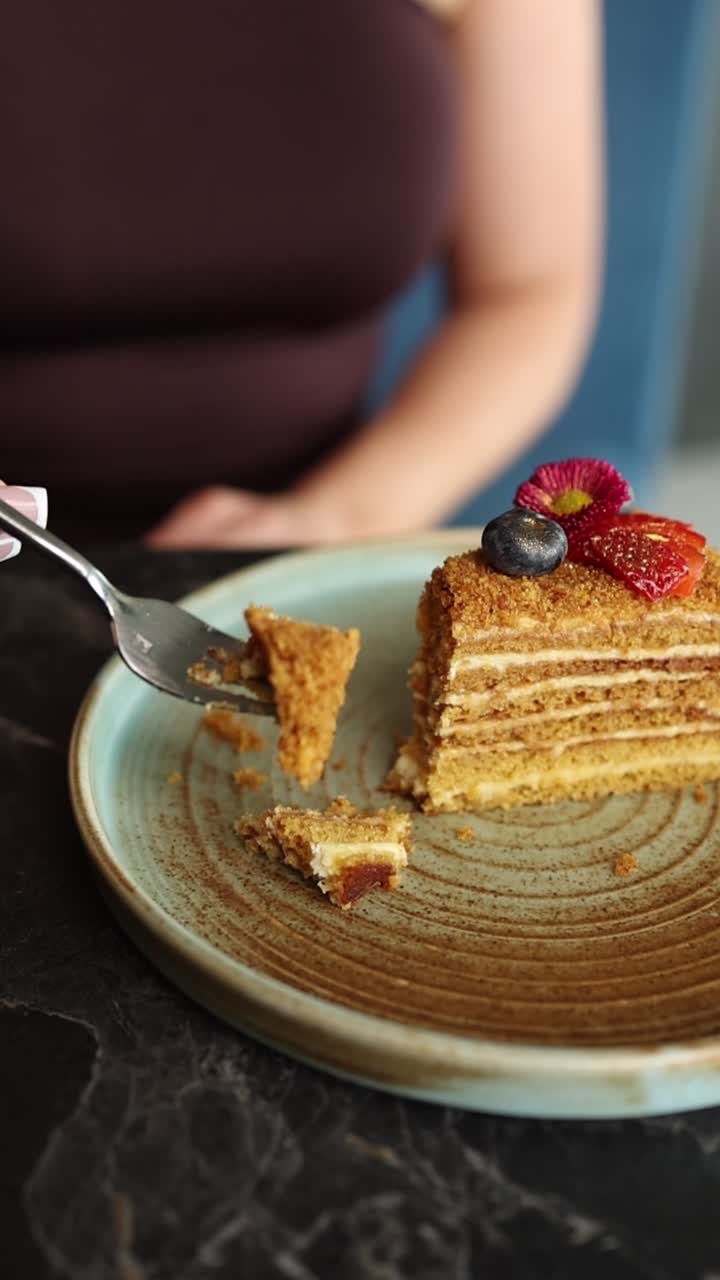 Крупный план: человек ест вкусный слоеный торт вилкой