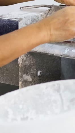 persona que enrolla y corta la masa con una máquina