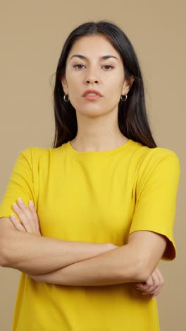 woman with crossed arms in yellow t-shirt