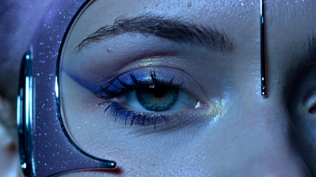 Opening model's left eye in studio after blink to reveal blue shadow, purple frame, metal bar