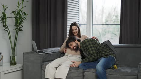 mujer embarazada con gran vientre y marido cerca de ella esperando movimientos