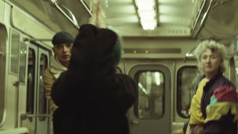 stylish girl dancing with team in subway train