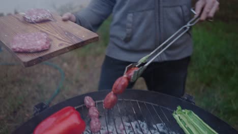 grilling outdoors with sausage, burgers, and vegetables