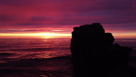 beautiful aerial vibrant high contrast pink purple sunset over baltic sea, karosta war port concrete coast fortification ruins at liepaja, wide angle drone dolly shot moving left