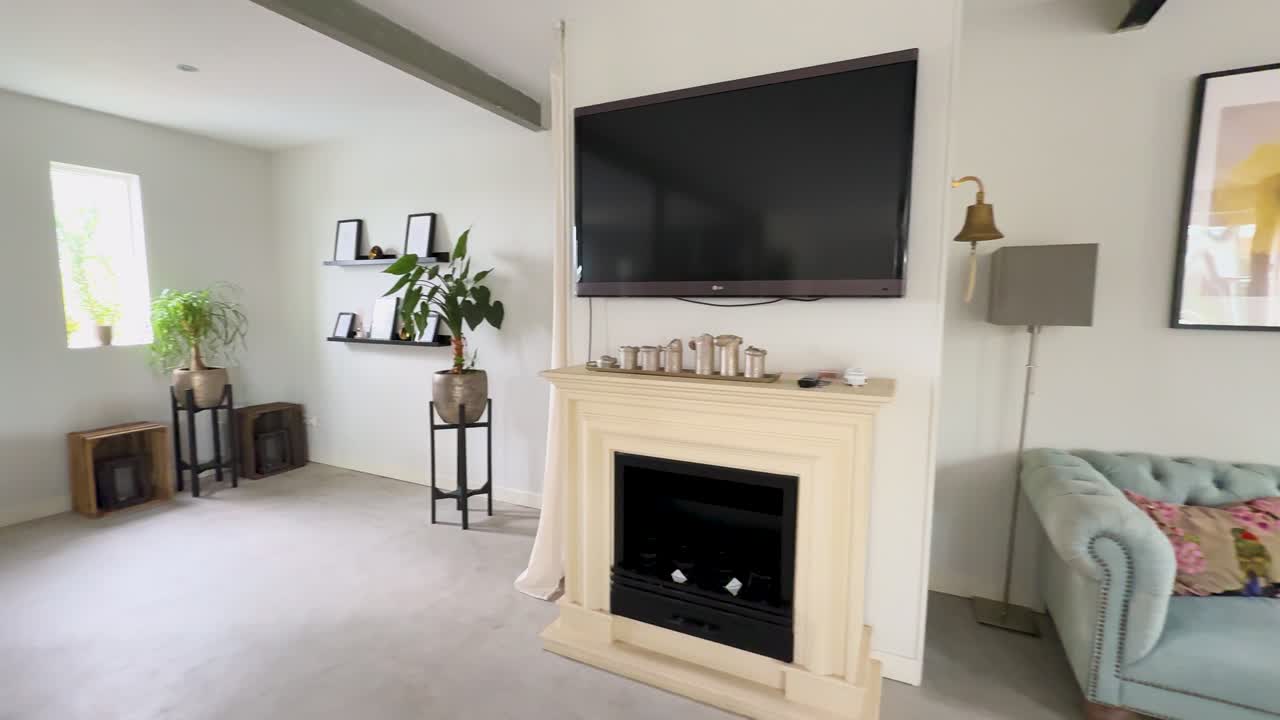 Tracking shot through a bright modern living space with fireplace, dining set, and piano