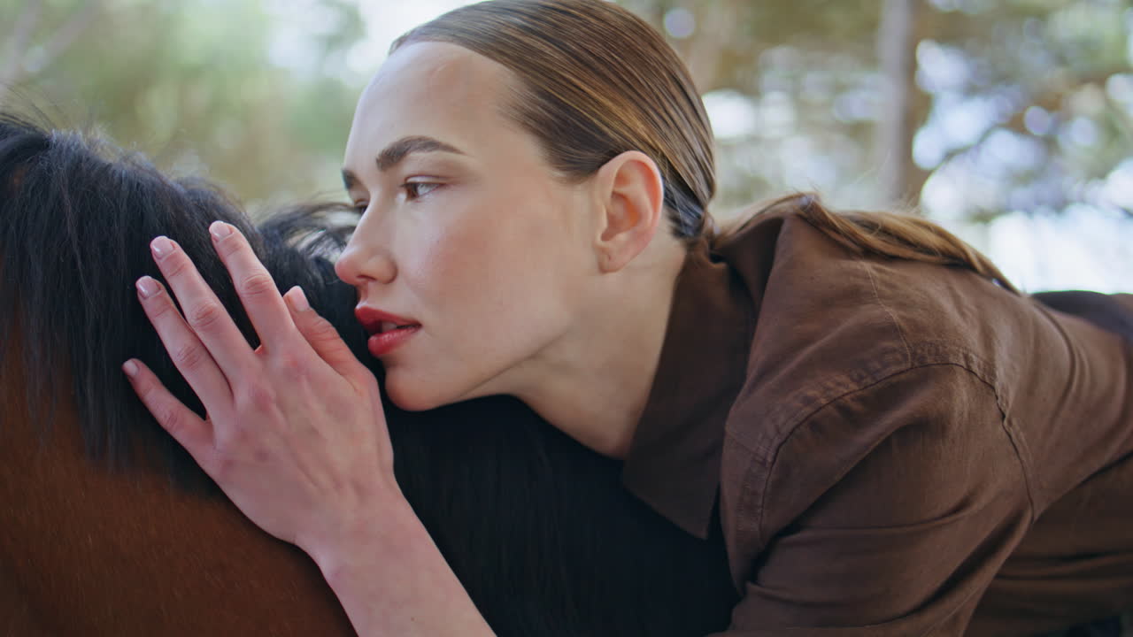 Affectionate model sitting horse on park portrait. Girl looking camera