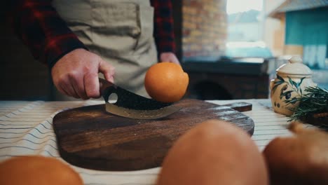 una persona cortando una naranja en una tabla de madera rústica en el interior, un ambiente de cocina acogedor