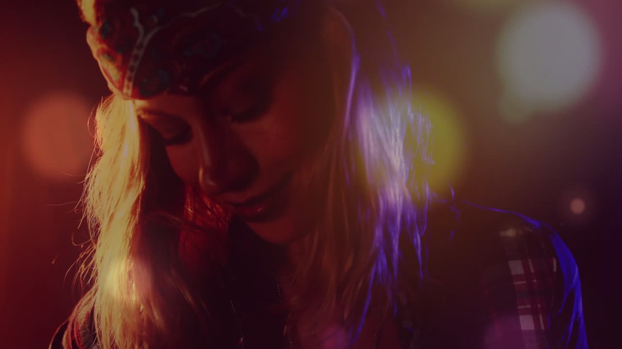 Mid-adult woman performing on club stage, showing animated light flares and bokeh for ads