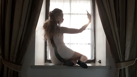 woman taking a selfie by the window