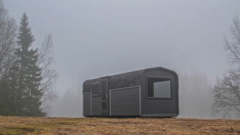 toma estática de niebla pasando con la vista de una cabaña de madera durante todo el día en timelapse