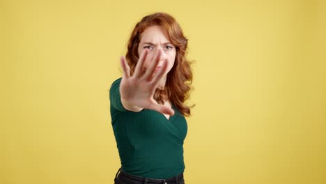 woman with red hair making a stop gesture