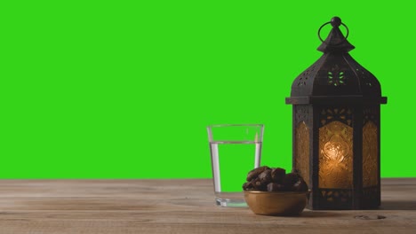 wide shot of lantern dates and water in front of green screen