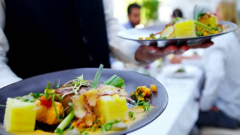 mid section of waiter holding food tray