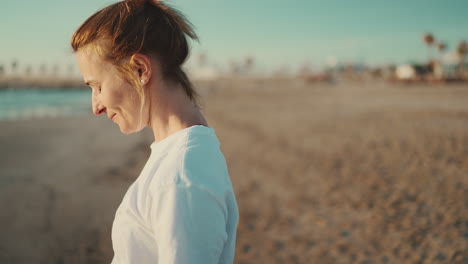 happy woman breathing fresh air and raising arms on the beach.