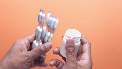 manos sosteniendo envases y frascos de medicamentos
