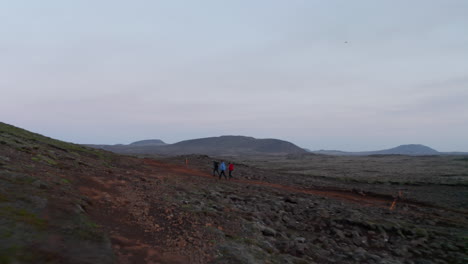 Surreal-aerial-view-moonscape-of-Iceland-desert-countryside.-Birds-eye-group-of-tourist-explorer-hikers-walking-pathway-in-icelandic-highlands